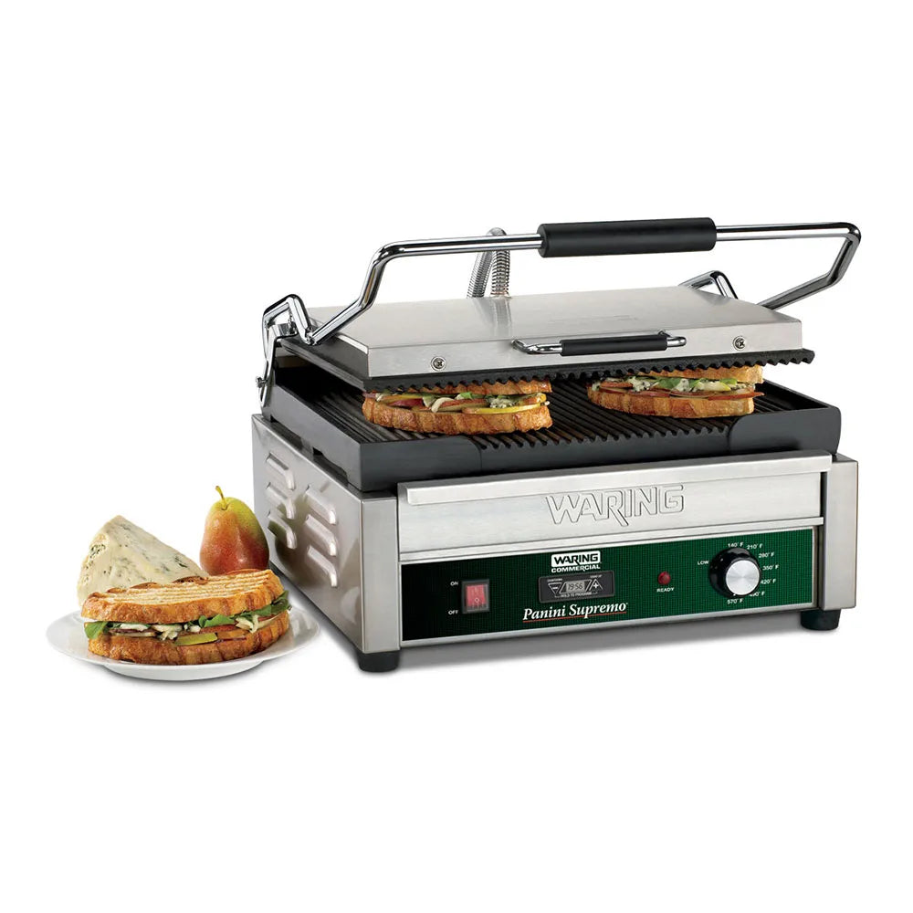 Waring WPG250T panini grill, lid open with grilled sandwiches, sandwich on a plate in front