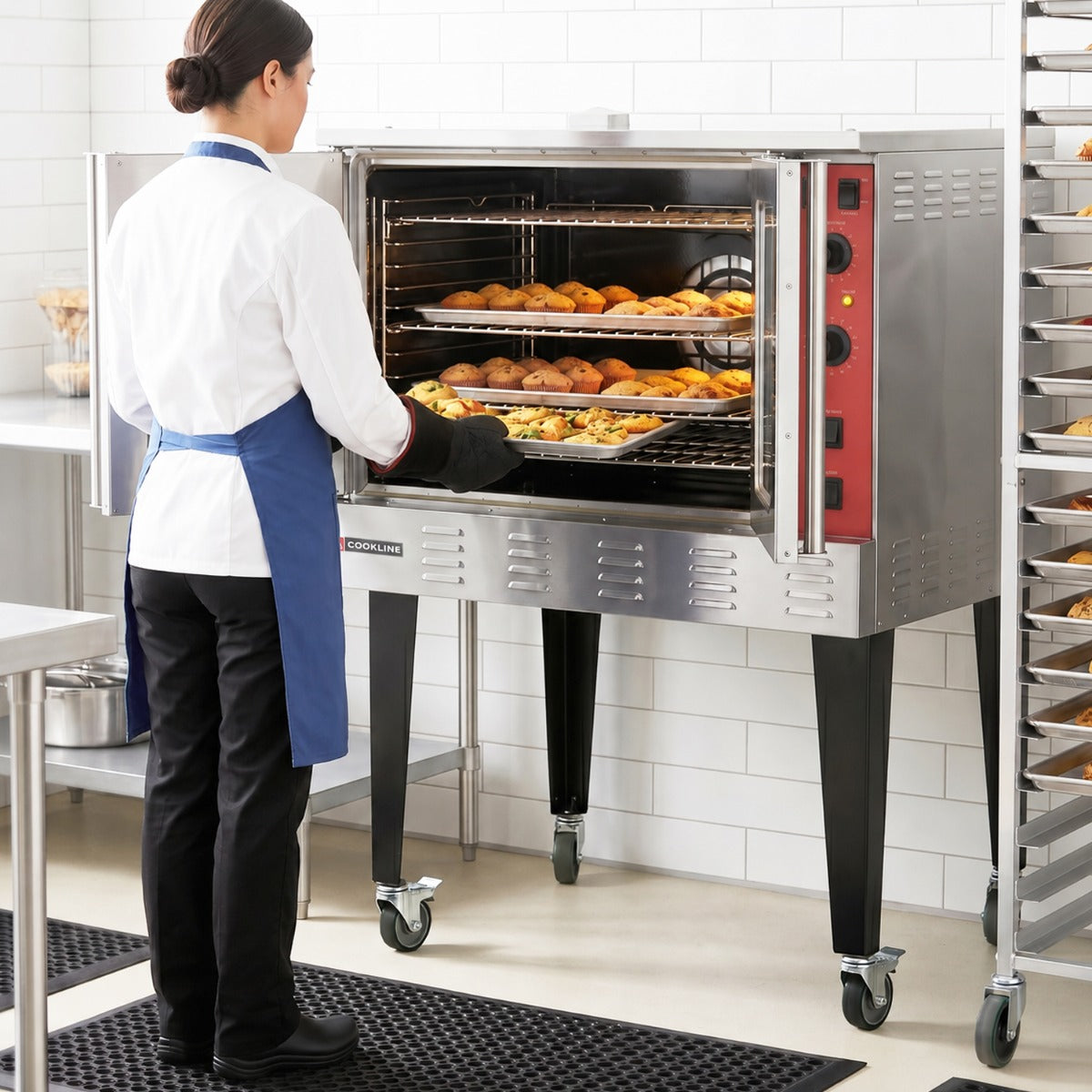 Cookline CC100-SGL single deck full size gas convection oven, in use, loading a tray of food in a kitchen