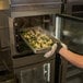 Henny Penny FlexFusion SpaceSaver Plus combi oven in use, cook loading a pan of food