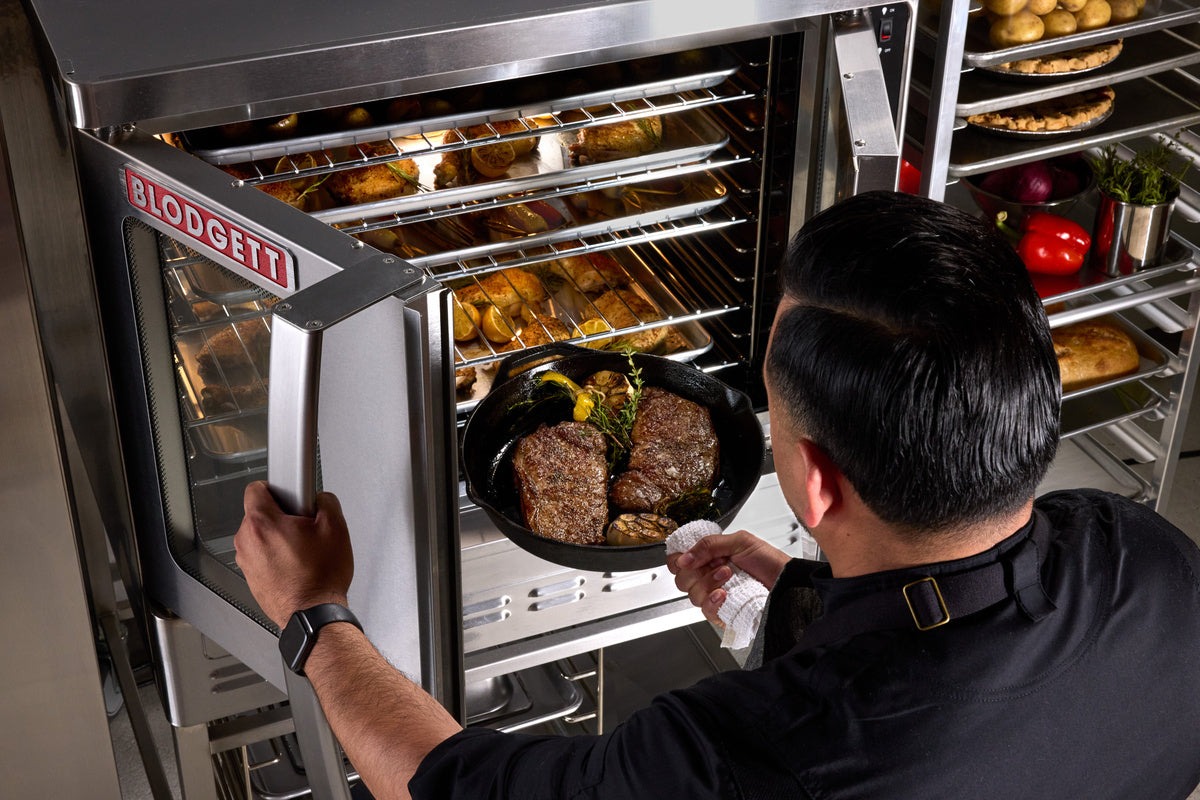 Cook taking a tray out of a Blodgett convection oven