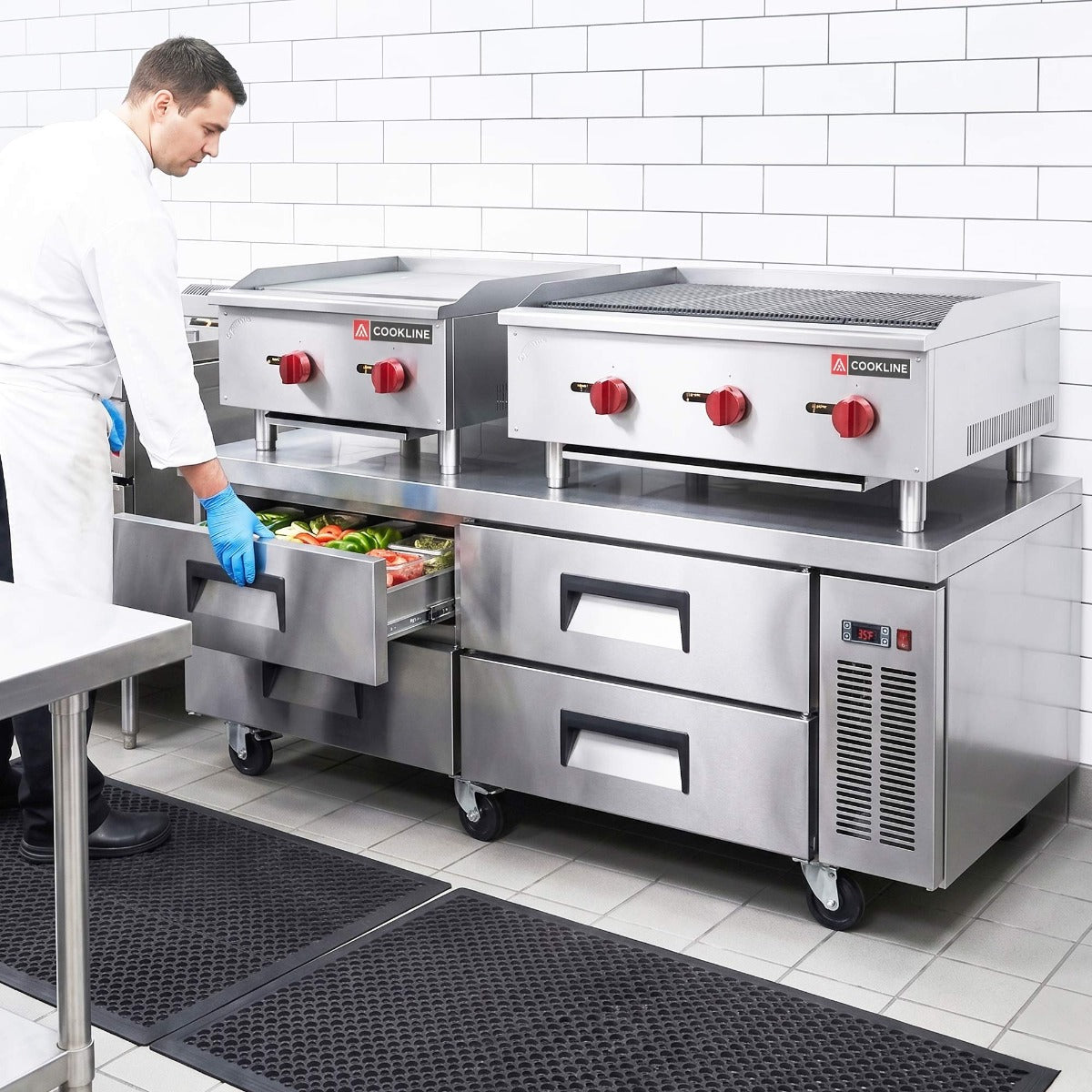 Coldline CB72 4-drawer refrigerated chef base, in use under two countertop griddles, lower drawer open (representative image)