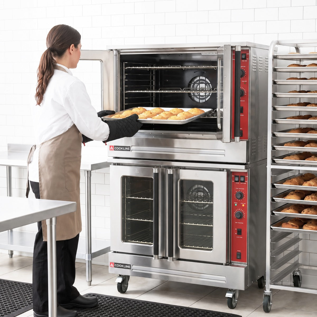 Cookline CV100-DBL-240-1 double deck electric convection oven, in use, a baker loading a sheet pan