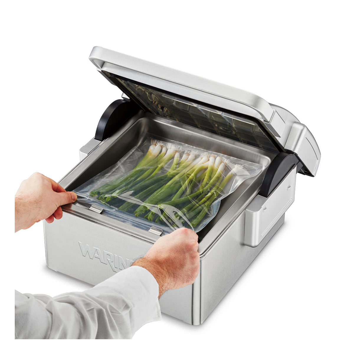 Waring WCV300 chamber vacuum sealer, placing a pouch of asparagus in the chamber